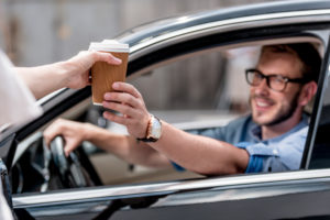 man in car with coffee